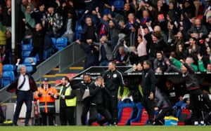 Slaven Bilic falls to his knees as Roy Hodgson and hiscoaching staff celebrate Wilfried Zaha’s 96th-minute equaliser.