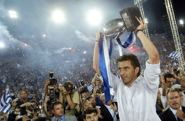 Greeks Salute The Return Of Their Victorious Football Team, led by their captain Theodoros Zagorakis as he raises the trophy during a victory fiesta at the Panathenaic Stadium in Athens, as thousands of Greeks welcomed the new UEFA Euro 2004 Champions.