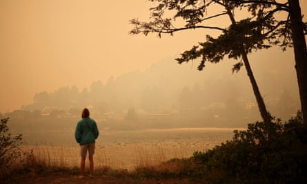 A person looks at a town by the Pacific Ocean coast as smoke from wildfires covers an area near Yachats, Oregon, on Tuesday.