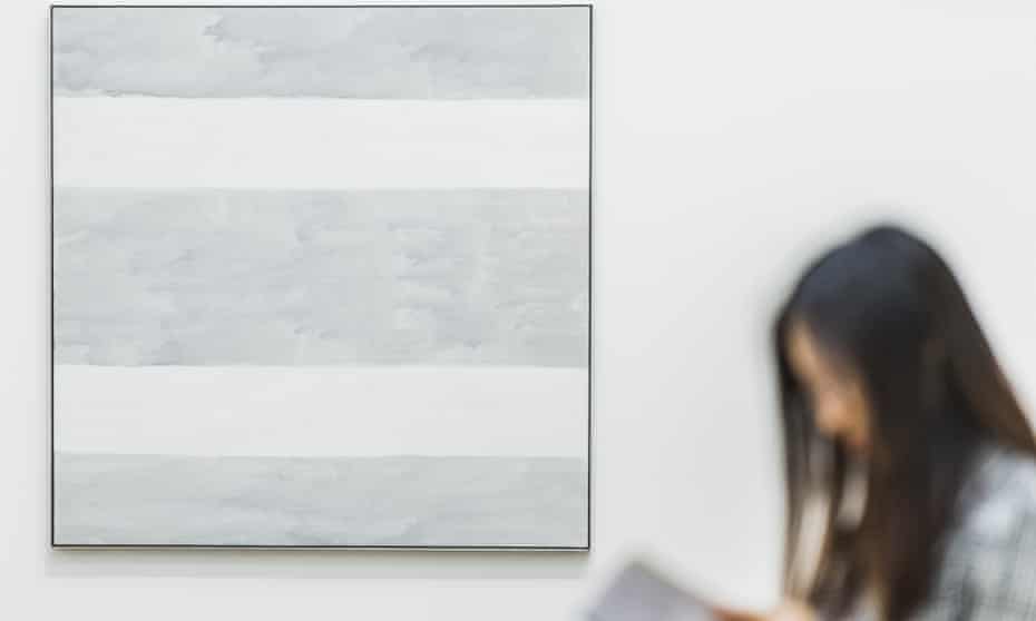 A viewer next to Agnes Martin’s final painting Untitled 2004, at Tate Modern in London. 