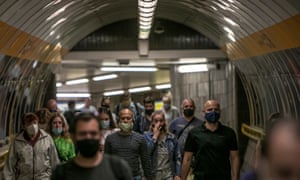 People wearing face masks walk at a metro station in Prague, Czech Republic.