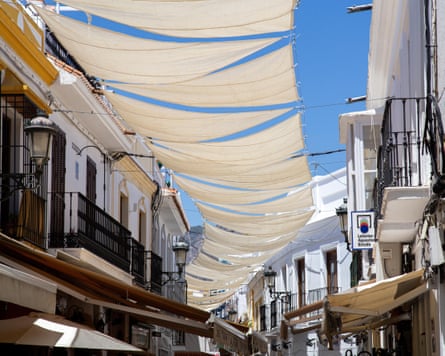 Shade sails between buildings over a street