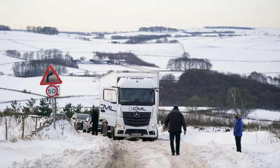 Motorcyclists are picked up by a snow-covered truck on the A515 near Biggin, in Peak District, Derbyshire.