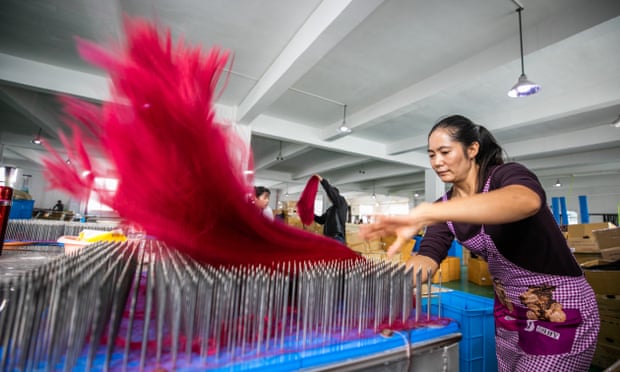Employees work on the production line of a wigs factory at Hanya Arts &amp; Crafts Co in Hezhang County