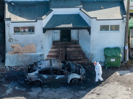 A man in protective clothing looks at the scene