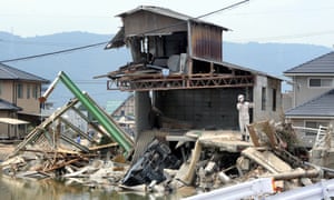 Officials in Kurashiki, Okayama, Japan, inspect the damage caused by torrential rain and flooding.