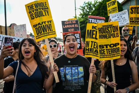 Protesters gather and wave yellow and black anti-ICE signs.