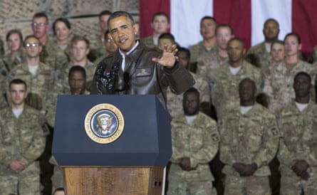 a man in front of a microphone with troops behind him