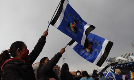 Supporters of Luis Arce hold flags with an image of Evo Morales