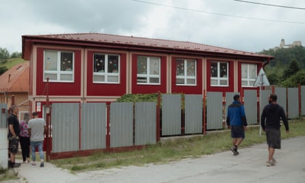 Locals walk past the primary school in Podsadek, Slovakia.