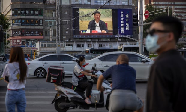 People on a street in Beijing with Xi Jinping on a giant TV screen