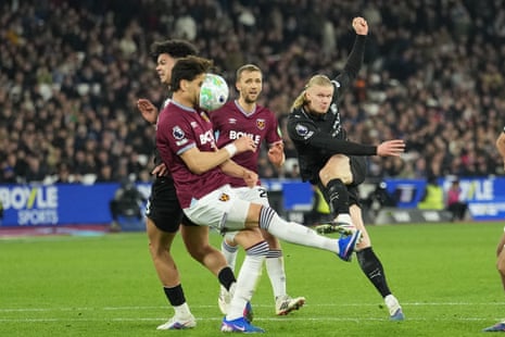 Konstantinos Mavropanos of West Ham gets whacked in the face by a shot from Erling Haaland.