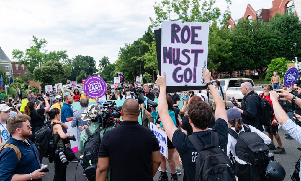 An anti-abortion demonstrator holds a sign reading 'Roe must go' near a pro-abortion march in Washington, on Monday.