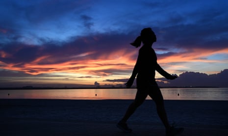 Woman walks at sunrise