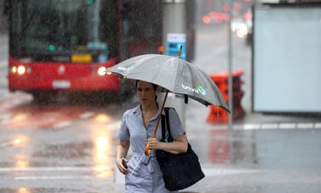 A woman with an umbrella walks in the rain in Sydney