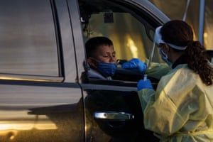 A healthcare worker attend to a child at a drive-thru Covid-19 testing site in El Paso, Texas.