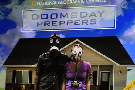 image of a couple wearing gas masks and standing in front of a home displayed on stage