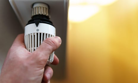 man turns down thermostat on radiator