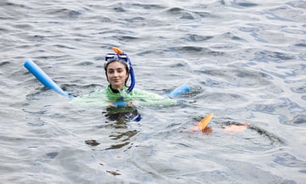 Guardian Australia journalist Rafqa Touma kitted out with a pool noodle and flippers, in the water during her first attempt at snorkelling.