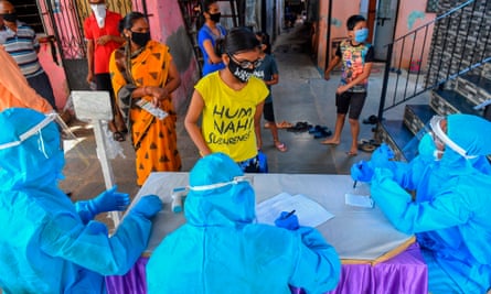 Slum residents wait for a medical check-up at a coronavirus screening centre in Mumbai.