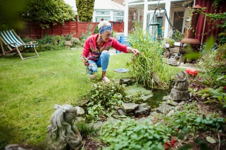 a woman cleans up her garden and pond