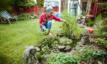 a woman cleans up her garden and pond