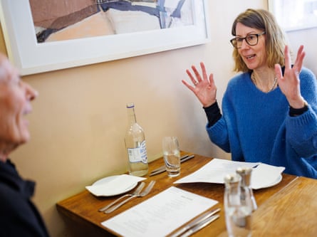A man and woman facing each other across a restaurant table