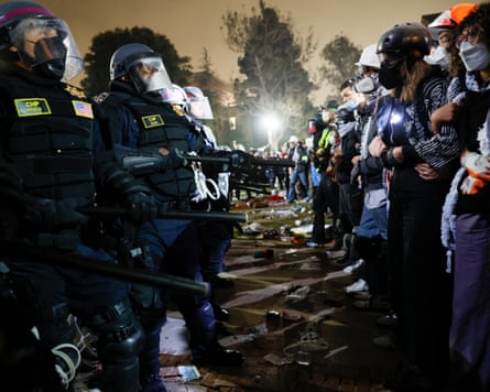 Police in riot gear face off with students in improvised protective gear