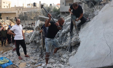 Israel-Hamas war live: White House promises ‘continued flow’ of Gaza aid as Israel steps up airstrikes in north of strip | Israel-Hamas war 13 Palestinians dig through the rubble of a building after Israeli strikes on Rafah in the southern Gaza Strip on Sunday.