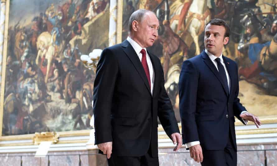 Emmanuel Macron (R) and Vladimir Putin (L) arrive for a joint news conference after a working meeting at the Versailles Palace, near Paris