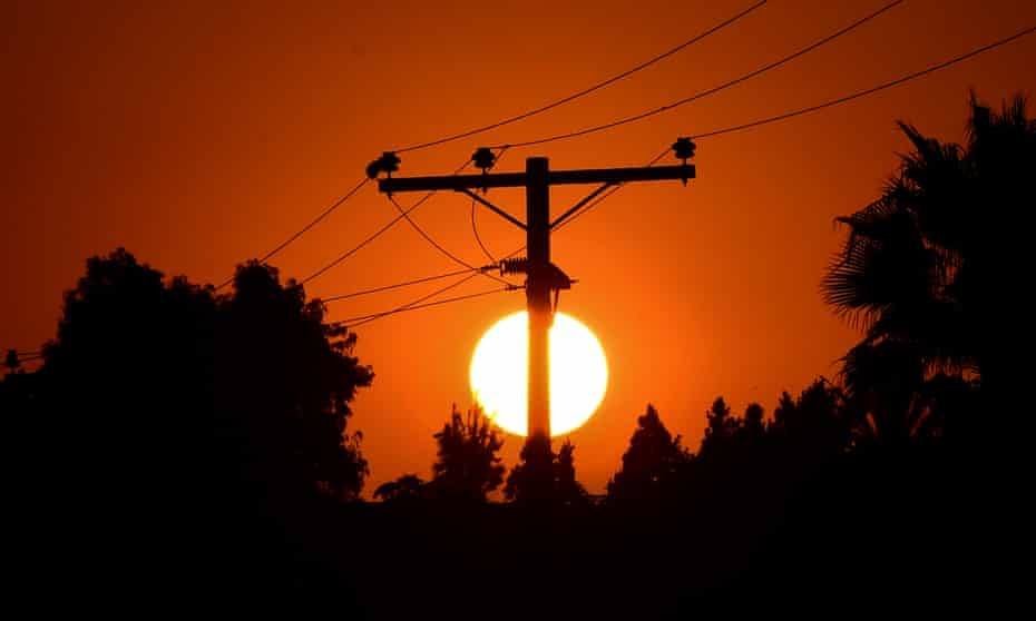 The sun sets behind power lines in Los Angeles, California, amid a record-breaking heatwave.