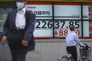 A man walks past an electronic stock board showing Japan’s Nikkei 225 index at a securities firm in Tokyo today