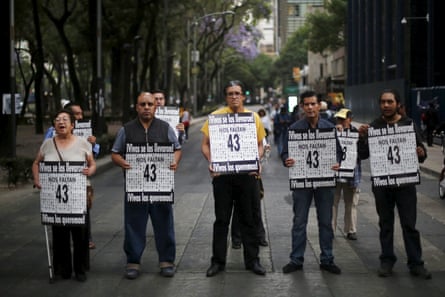 Activists hold signs to demand justice for the 43 missing students of Ayotzinapa Teacher Training College, outside the office of Mexico’s attorney general in Mexico City, 4 April 2016. The signs read: ‘Alive they were taken. Alive we want them.’