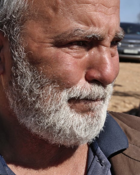 Closeup of a grey-bearded Eshaq looking emotional and distressed