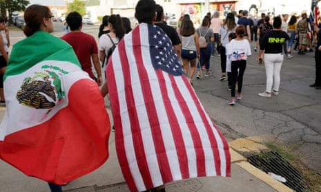 People with the Mexican flag and the US flag take part in a rally against hate one day after a mass shooting at a Walmart store in El Paso, Texas.