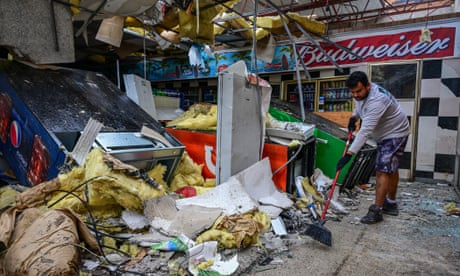 A man cleans debris strewn inside a gas station