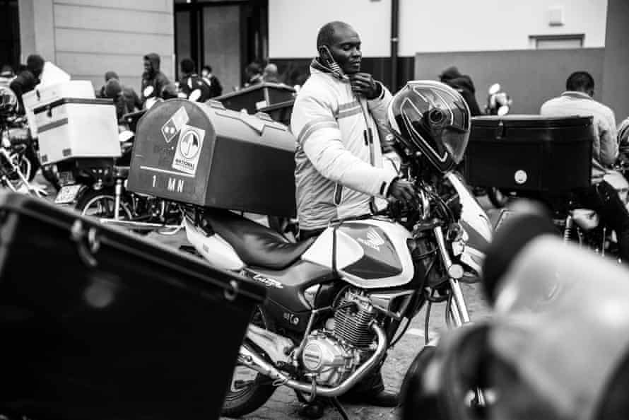 Ghost riders: the invisible lives of Johannesburg food couriers – photo essay | South Africa 11 Mukisa arrives at the shopping centre where he waits for food orders