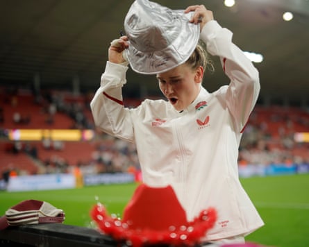 England centre Meg Jones tries on a hat she has just signed next to others that have been placed on advertising boards for players to autograph on a lap of honour after the Women’s Rugby World Cup 2025 Group A match between England and USA.