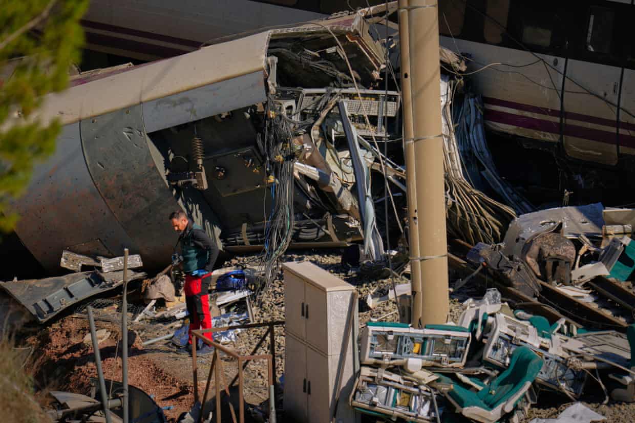 A Guardia Civil collects evidence from the wrecckage of a rail collision.