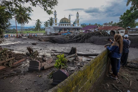 People look at a flood affected area after a flash flood in Tanah Datar, West Sumatra