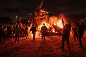 People stand around a bonfire