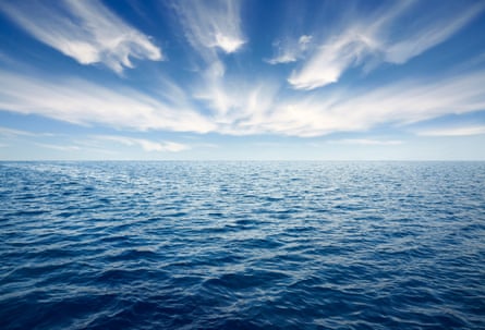 An image of a wide expanse of sea with a blue sky and cirrus clouds