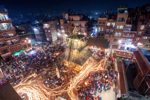 Aerial picture of people carrying a ceremonial palanquin and torches