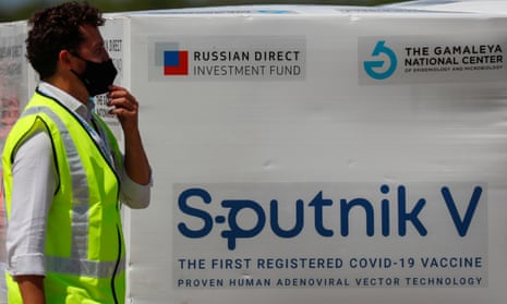 Airport worker in Buenos Aires standing next to boxes of Sputnik V Covid vaccine