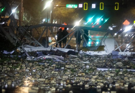 A group is silohetted against a fallen crane along 1st Avenue South near the Tampa Bay Times offices in St Petersburg.