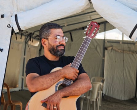 Ahmed Abu Amsha holding a guitar