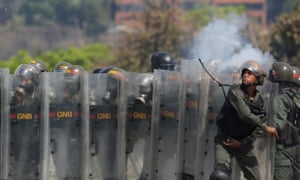 Member of the National Guard throws an object towards opposition supporters on Wednesday.