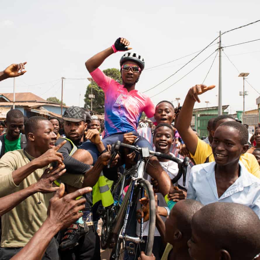 Moses Kamara and his bike are carried aloft after his stage victory on stage three of the Lunsar Tour.