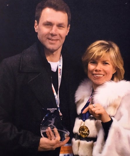 two people holding awards and medals