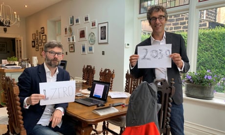 The scientists Joeri Rogelj and Piers Forster hold up signs urging a reduction in carbon emissions, after completing the major UN climate report